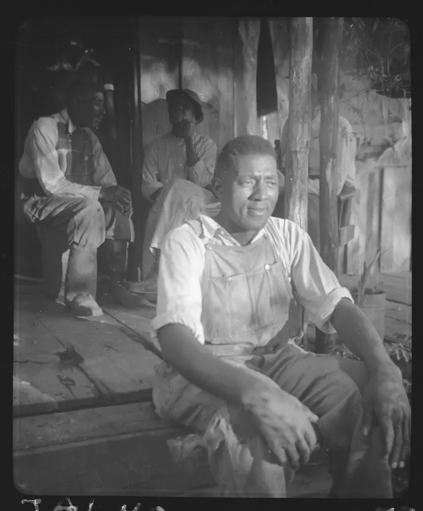Jim McDonald, on porch of parents' home, with Uncle Joe McDonald and Aunt Mollie McDonald in background, near Livingston, Alabama